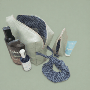 Ensemble de voyage artisanal La Petite Promenade avec trousse de toilette et pochette en coton vert sauge.