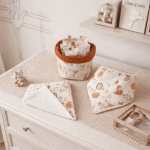 Mise en situation d'un ensemble de soin pour bébé sur une table à langer en bois, thème forêt et animaux mignons.