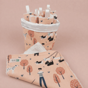 Gros plan sur un panier en coton imprimé contenant 7 lingettes lavables réutilisables avec boucles d'accrochage.