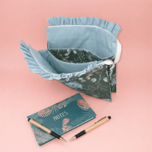 Pochette artisanale pour tablette en coton imprimé floral vert et finitions froncées bleues.