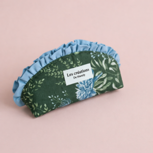 Trousse en tissu artisanal vert forêt avec motif floral et volant bleu ciel, étiquette "Les créations de Mamily".