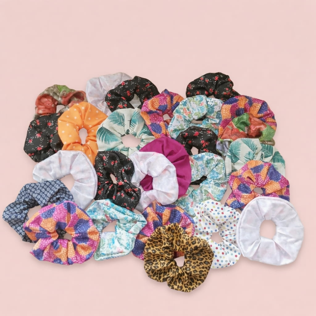 Assortiment de 6 chouchous colorés en coton et satin pour cheveux, posés sur un fond rose poudré.