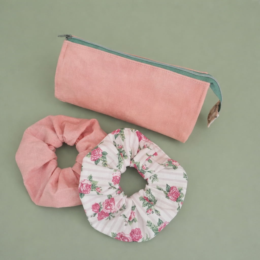 Trousse de toilette artisanale en coton rose avec deux chouchous assortis motif roses d'antan sur fond vert pastel.