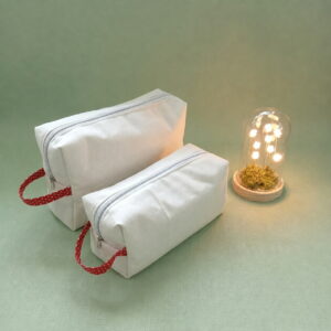Duo de trousses de toilette en coton canva blanc avec anses à motifs petits cœurs rouges sur fond vert sauge.