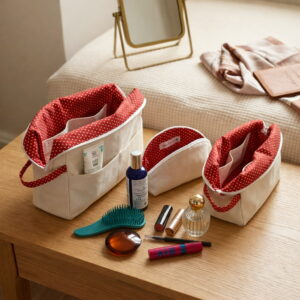 set-3-trousses-voyage-artisanales-canvas-beige Intérieur de trousses de toilette ouvertes montrant les poches de rangement remplies de produits de beauté et pinceaux.