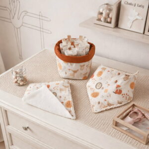 coffret-bebe-lingettes-lavables-serviette-bavoir-bandana Mise en situation d'un coffret de soin pour bébé comprenant un bavoir bandana, une petite serviette et un panier de 7 lingettes lavables en éponge bambou